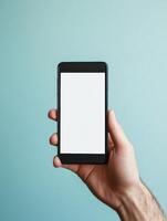 Close up of hand holding smartphone on blue background for technology design photo