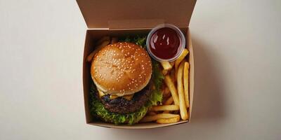 Delicious burger and fries meal in takeout box with ketchup for convenient dining experience photo