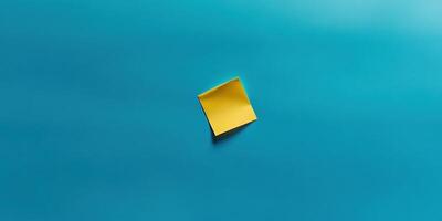 Minimalist top down composition of a blank yellow sticky note on a blue background photo