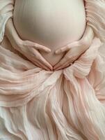 Expecting motherhood. Hands cradling pregnant belly in soft fabric photo