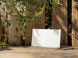 Minimalist business card mockup against rustic wooden fence with greenery photo