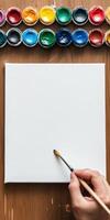 Artist perspective. Preparing to paint on a blank canvas with colorful paints photo