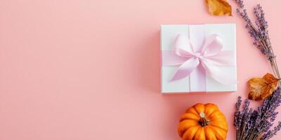 Elegant gift box with satin ribbon and autumn elements flatlay for seasonal celebrations photo