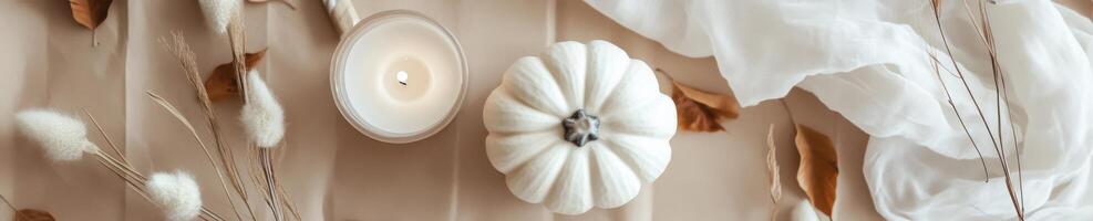 Elegant Halloween flat lay with white pumpkin, candle, and autumn leaves for seasonal decor photo