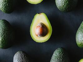 Fresh and healthy assorted avocados on dark background for culinary inspiration photo