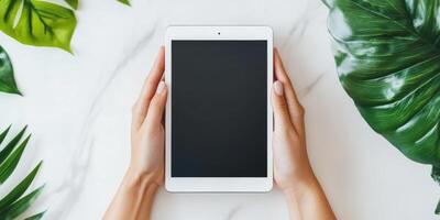 Hands holding sleek tablet on marble surface for technology and business presentation photo