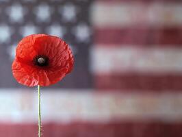 Ultra realistic single red poppy with with American flag background for memorial or veterans remembrance photo