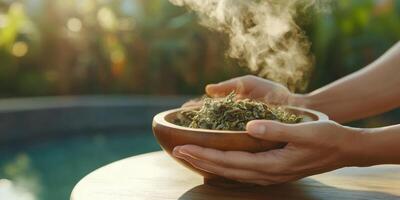 Professional spa therapist preparing warm herbal treatment by poolside photo