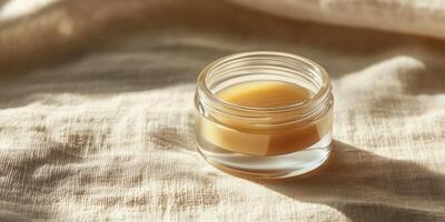 Clear lip balm container on fabric surface for skincare and beauty products promotion photo