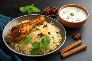 Delicious chicken biryani with raita and spices is a flavorful and aromatic culinary creation on a dark background photo