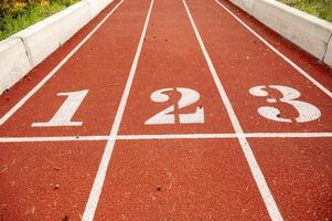 Red running track in stadium,with numbers at the start. Sport recreation. Helthy lifestyle concept. High quality photo