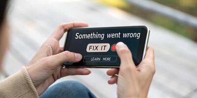 Someone holding a smartphone with something wrong text photo