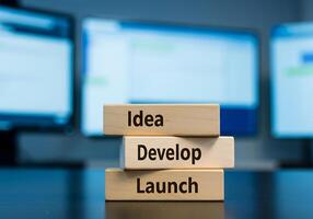 stack of wooden blocks with the words idea, develop and launch photo
