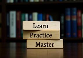 stack of wooden blocks with the words learn practice master photo