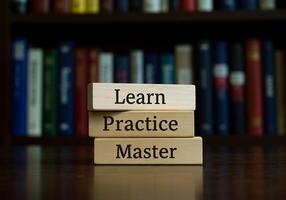 Three wooden blocks with the words learn practice master photo