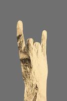 Rock gesture with hand showing golden metallic horns, symbolizing energy, rebellion, and enthusiasm. photo