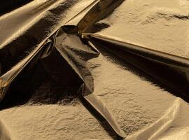 Golden foil reflective folds with a shiny, metallic finish. Luxurious, crumpled texture creating a photo
