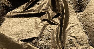 Bright gold foil drapery with a polished, sleek surface. Premium metallic fabric with a fine, smooth photo