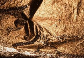 Copper foil with glossy, shiny metallic texture creates a dramatic, reflective surface. Wrinkled, photo