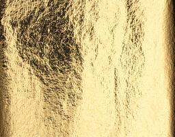 Gold metallic foil background. Shiny golden texture with reflective light, distressed finish, and photo