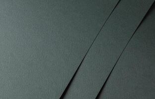 Paper texture with dark green tone, layered sheet and geometric line overlay, clean matte surface photo
