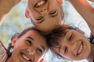 Close up face of happy children embracing each other and smiling, group of joyful kids playing together outside. photo