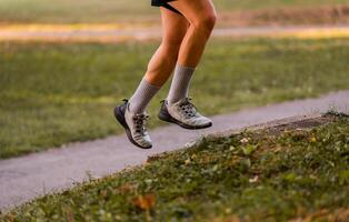 Cropped image of a sporty running man in cross country trail run. photo