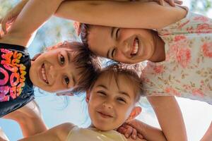 Happy children embracing each other having fun and smiling at camera, group of joyful kids playing together outside. photo