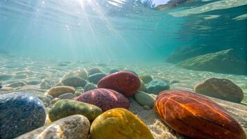 Underwater view of colorful stones in clear river. underwater view of red and yellow pebbles on the seashore with sunlight. photo