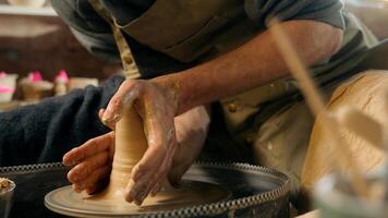 Man create new clay product sculpting modeling vase jug pot bowl master male professional craftsman seller creator potter pottery small business artisan in workshop hobby handicraft handwork clayware photo