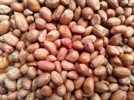 Pile of peanut seeds. Raw peanuts. Nuts without shell. Nutritious food, protein and minerals. For background. photo