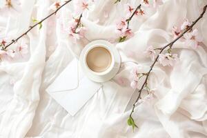 White cup with a coffee in it sits on a table with a white sheet photo