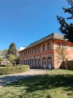Karlsruhe, Germany - March 19, 2023 - A large red building with a white roof and white windows photo