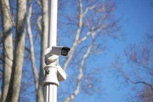 Security camera mounted on pole in clear sky photo
