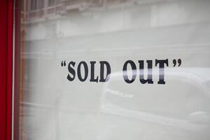 Shop display shows sold out sign on window photo