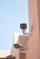 Surveillance cameras mounted on a building in bright daylight photo