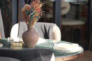 Dining table set with decorative vase and flowers in a restaurant photo