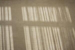 Light patterns creating shadows on a textured surface in the afternoon photo