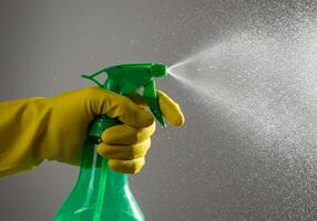 Spraying Liquid Cleaner with Glove for Cleaning Action photo