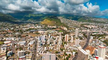 Varied urban landscape of densely built Honolulu, Hawaii, USA. Aerial perspective eon the city under the grey cloudy sky. photo