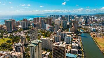 Approaching Ala Wai Canal outlining Waikiki in Honolulu, Hawaii, USA. Grey cloudscape floating in the sky over the mountains. Aerial view. photo