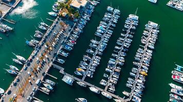 Yacht club with numerous vehicles at the piers. Multiple cars are parked near the yachts photo