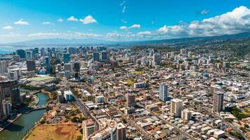 Varied urban landscape of densely-built Honolulu, Hawaii, USA. Aerial perspective eon the city under the grey cloudy sky photo