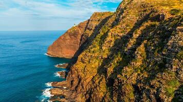 Stunning unapproachable rocks descending into the ocean. photo