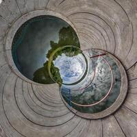 A circular hole with a view of a lake and sky photo