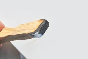 Close up of burning palo santo wood stick with smoke for aromatherapy and purification. photo