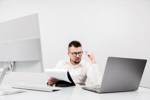 A businessman, financial manager or recruiter, works at a computer in a modern office. The concept is to show the focus and productivity photo