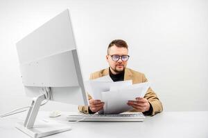 Businessman at a computer in an office, analyzing stock market and inflation charts, sorting through papers. White background photo