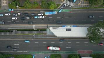Aerial top-down view of busy multilane street with morning traffic, bus stop, and motorbike lanes in Jakarta, Indonesia. Ideal for transport, infrastructure, and Southeast Asia urban themes. video
