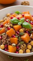 A bowl of quinoa salad with squash, nuts and seeds photo